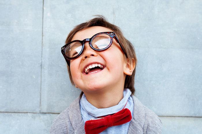 Child with bow tie and glasses smiling